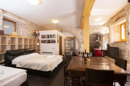 a bedroom with a bed and a dining room with a table at Galera in Šibenik
