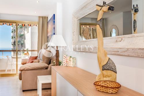 un salon avec une sculpture en bois d'une girafe sur un comptoir dans l'établissement Modern 1 BR apartement in very center of Marbella., à Marbella