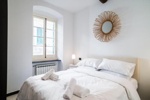 a bedroom with a large white bed with a mirror at Nel Cuore di Santa in Santa Margherita Ligure