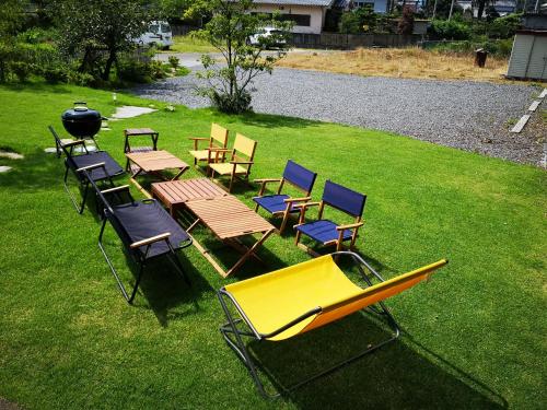 a group of chairs and tables and a grill on a lawn at OMISHIMA SPACE Omoya in Imabari