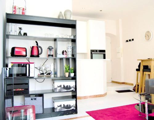 un salon avec une étagère noire et des appareils électroménagers dans l'établissement Studio Maccarani, à Nice