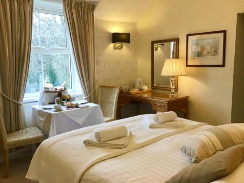 a hotel room with a bed and a table and a window at Fernbank in Shanklin