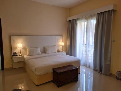 a bedroom with a large bed and a large window at Clarence Apartment in Ras al Khaimah