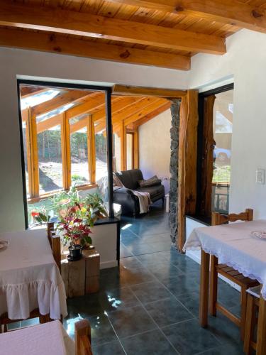 sala de estar con 2 mesas y sofá en Acceso Bayo - ubicada en el acceso al cerro bayo 3km del centro en Villa La Angostura