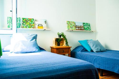 two beds in a room with blue sheets at Mareao FamaraBeach in Famara