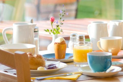 a table topped with cups and plates of breakfast food at ad vineas Gästehaus Nikolaihof-Hotel Garni in Mautern