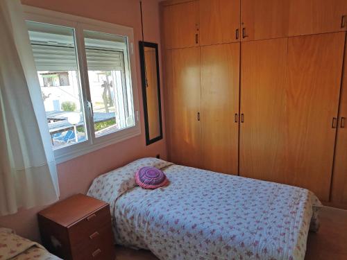 ein Schlafzimmer mit einem Bett mit einem lila Hut darauf in der Unterkunft Apartamentos Estival 3000 in La Pineda