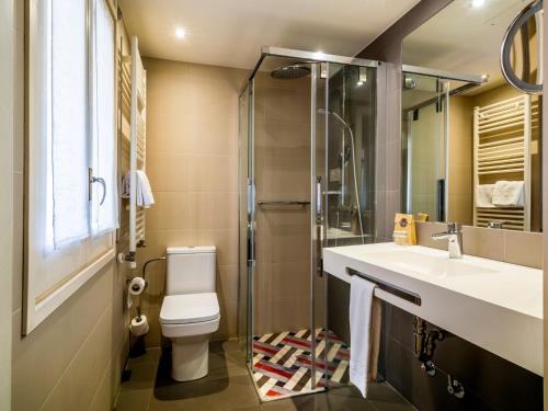 a bathroom with a toilet and a sink and a shower at Balneari Termes Victòria in Caldes de Montbui