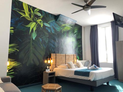 a bedroom with a bed with a tropical wallpaper at Hotel de France Citotel in Rochefort
