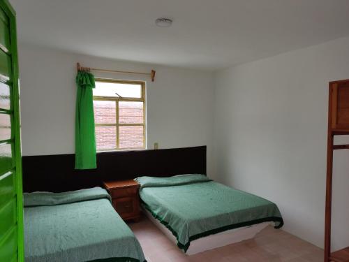 a bedroom with two twin beds and a window at Hotel Tivoli in San Cristóbal de Las Casas
