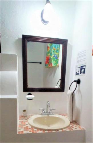 a bathroom with a sink and a mirror at Hotel Casa de las Flores in Playa del Carmen