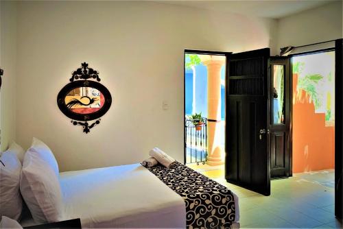 a bedroom with a bed and a clock on the wall at Hotel Casa de las Flores in Playa del Carmen