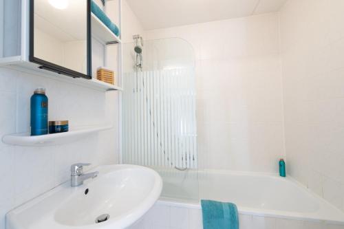 ein weißes Badezimmer mit Waschbecken und Badewanne in der Unterkunft Grimaud 179 - Kustpark Village Scaldia in Hoofdplaat