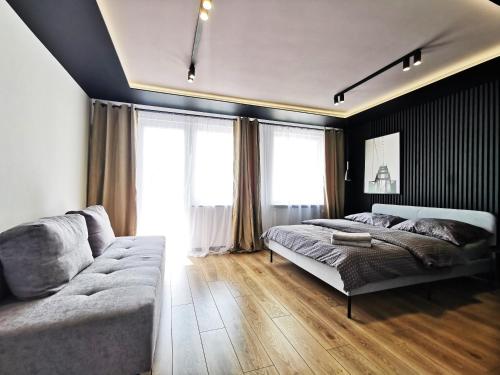 a bedroom with a bed and a couch at Gliniana Apartment ~ Self check-in 24h ~ Lift in Wrocław