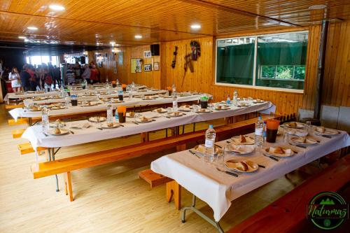 uma grande sala de jantar com mesas com pratos de comida em Albergue Naturmaz em Mazaricos