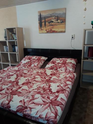 Un dormitorio con una cama con flores rojas. en Ferienhaus Familie Heise, en Bad Salzungen