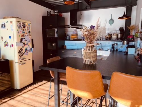une cuisine avec une table avec des chaises et un réfrigérateur dans l'établissement Magnifique villa avec piscine, à Alès