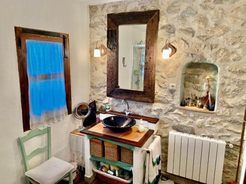 baño con lavabo y espejo en la pared en Casa Tatisita III, en Segura de la Sierra