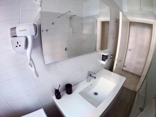 bagno bianco con lavandino e specchio di Casa Bagai a Milano