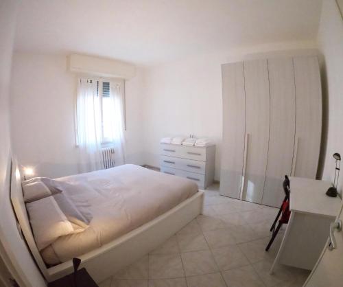 ein weißes Schlafzimmer mit einem Bett und einer Kommode in der Unterkunft Casa Bagai in Mailand