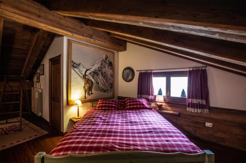 una camera da letto con un grande letto in mansarda di L'Atelier du Temps - Chalet Les Marmottes a Cogne