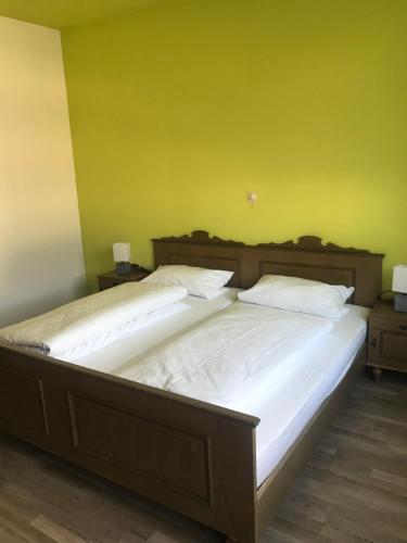 two beds in a room with a green wall at Gasthof und Pension Zur Frischen Quelle in Heigenbrücken