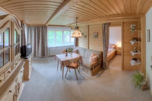 a living room with a table and a bedroom at Haus Singer in Bad Feilnbach