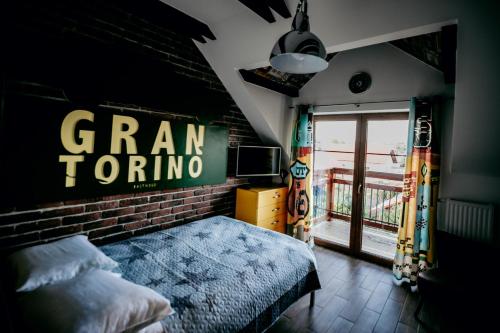 a bedroom with a bed with a sign on the wall at Jantarvia Car Museum , Pasja i Wypoczynek Noclegi z Klimatem in Jantar