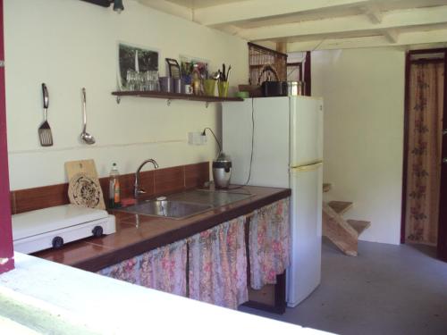 a kitchen with a sink and a refrigerator at Riversideview House in Calibishie