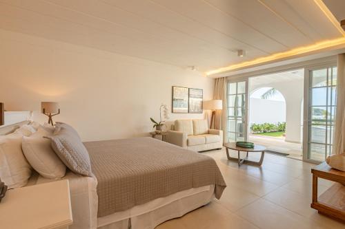 a bedroom with a bed and a living room at Villa Raphael in Búzios