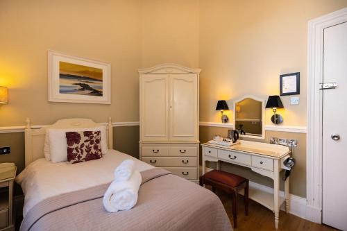 a bedroom with a bed with a desk and a sink at The Haymarket Hotel in Edinburgh