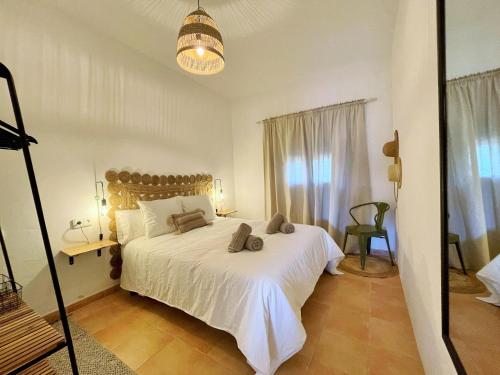 um quarto com uma cama branca e uma janela em Apartamentos Carabela em Playa Migjorn