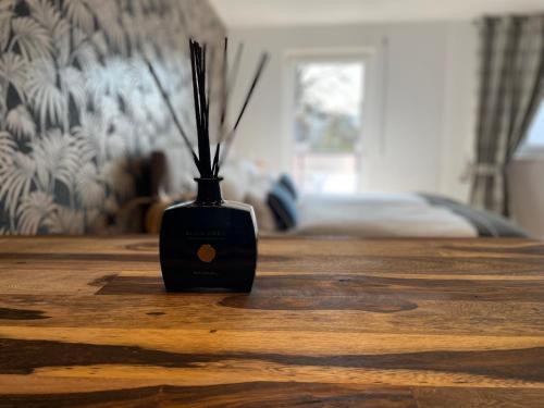 a black vase with sticks in it sitting on a table at Design Apartment Catch Me If You Can in Freiburg im Breisgau