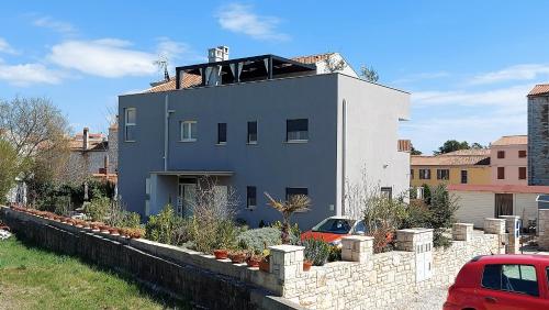 a white house with a roof on top of it at Rooms and Apartments IstraSoley in Bale