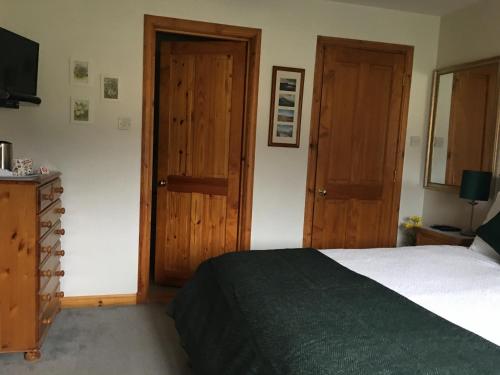 a bedroom with a bed and two wooden doors at Taigh Pa in Uig