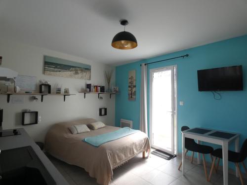 una camera da letto con un letto, una scrivania e una televisione di Grain de Sable et son Jacuzzi a Talmont