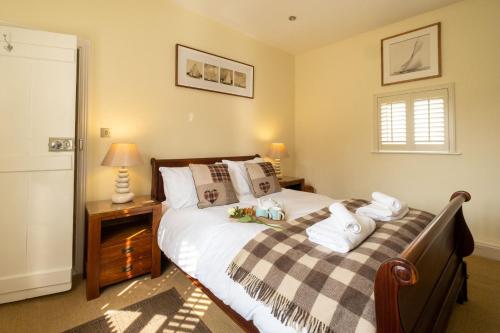 um quarto com uma cama com um cobertor xadrez em Pebble Cottage - 6 Victoria Rd - Aldeburgh Coastal Cottages em Aldeburgh