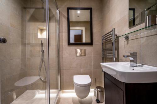 a bathroom with a toilet and a sink and a shower at 201@ Ryedale House in York
