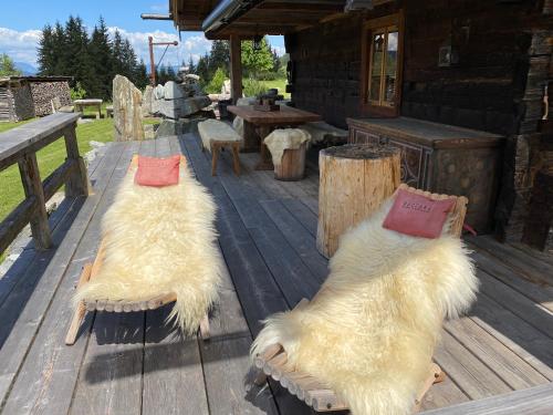 zwei weiße Hunde auf einem Holzdeck in der Unterkunft Buccara Zwischenbachalm in Westendorf