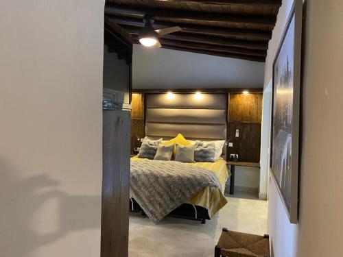 um quarto com uma cama com lençóis e almofadas amarelas em Quinta Omorka Cottage em Lagos