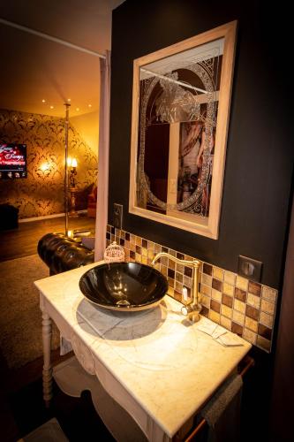 La salle de bains est pourvue d'un lavabo et d'un miroir. dans l'établissement Nuances d'Alcôves, à Trévron