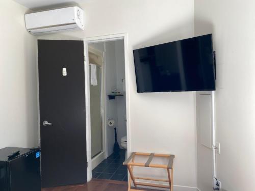 a room with a flat screen tv hanging on a wall at Hotel Belley in Quebec City