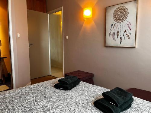 - une chambre avec un lit et 2 serviettes vertes dans l'établissement Superbe appartement face mer, à Le Touquet-Paris-Plage