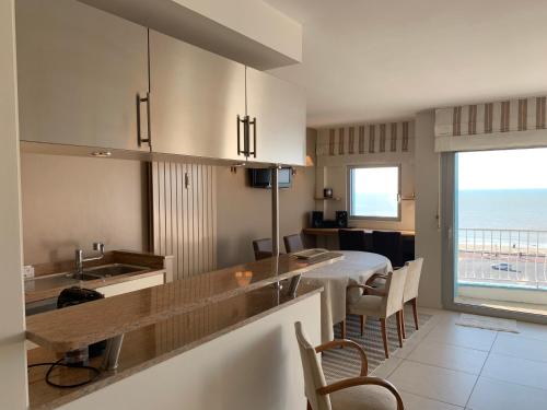 - une cuisine avec une table à manger et une vue sur l'océan dans l'établissement Superbe appartement face mer, à Le Touquet-Paris-Plage