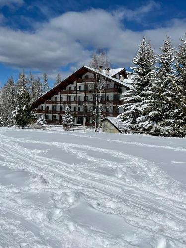 a large building in the snow with snow covered trees at Fiocco di neve in Pila