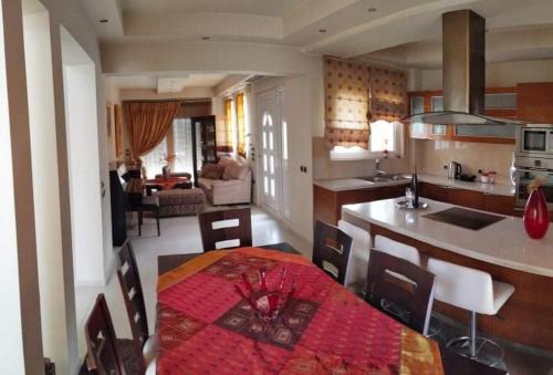 a kitchen and living room with a table and a dining room at Villa Katerina in Ialyssos