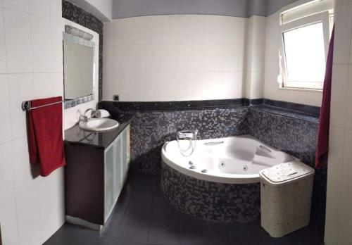 a bathroom with a large tub and a sink at Villa Katerina in Ialysos