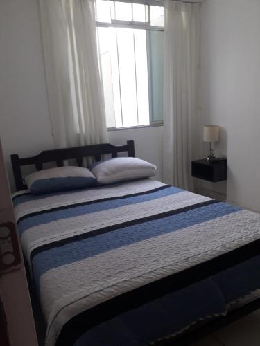 a bedroom with a bed with a blue and white blanket at Ambigua Hospedaje in Trujillo