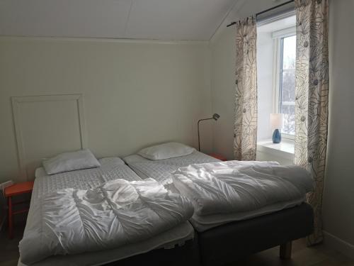 a bedroom with two beds and a window at Fjällägenhet boende Huså Byskola in Huså