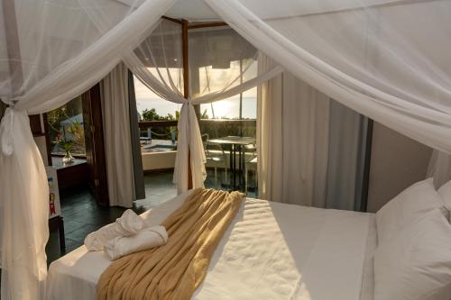a bedroom with a canopy bed with a balcony at Casa de Férias Casa Mia in Santa Cruz Cabrália